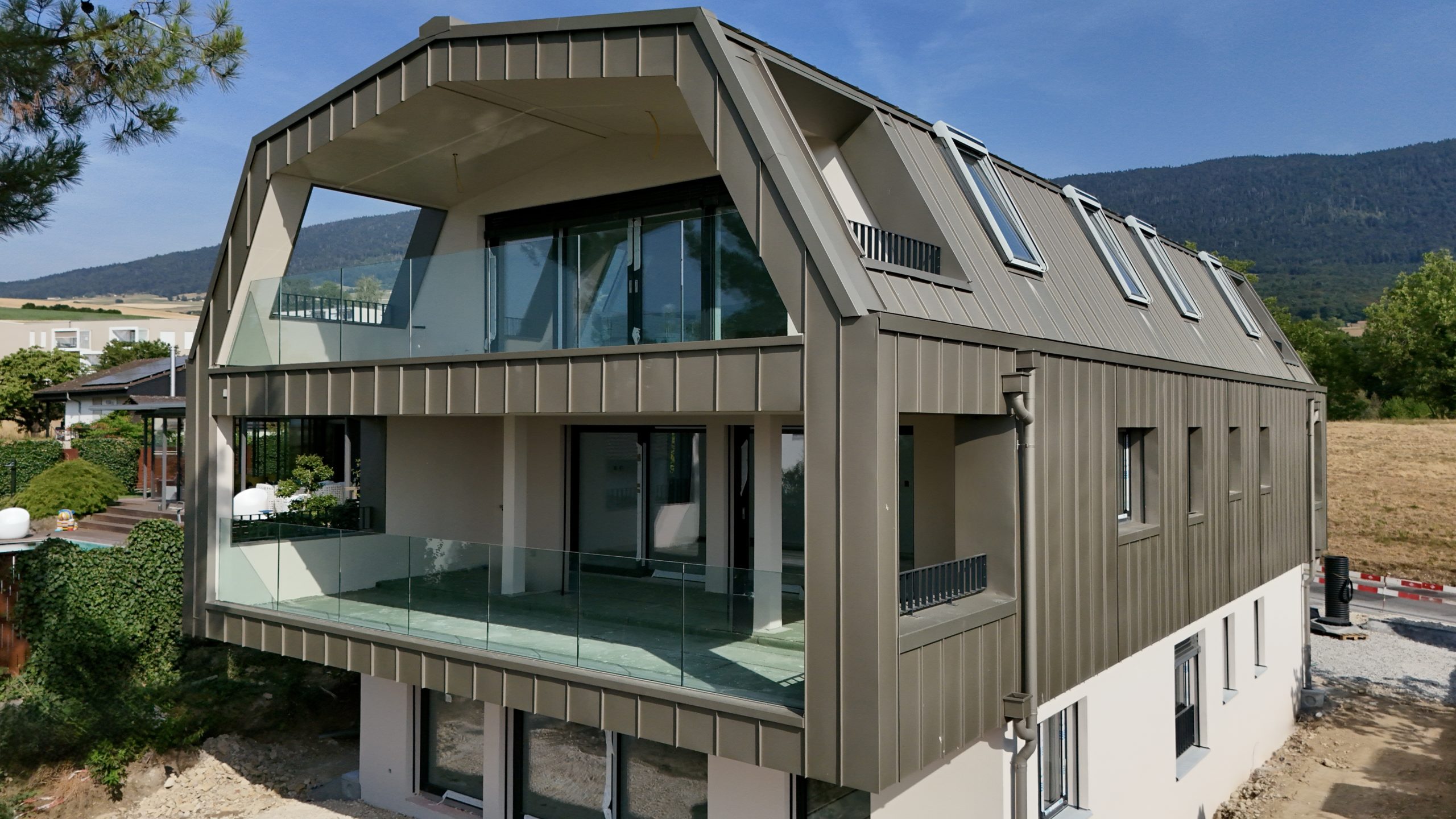 Immeuble contemporain à Saint-Aubin-Sauge avec façade métallique et balcons vitrés